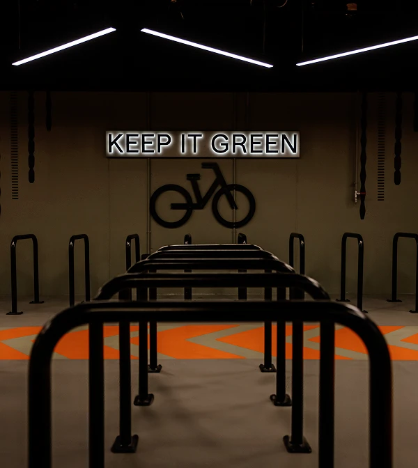 Underground bike rails with 'Keep It Green' sign on the wall.