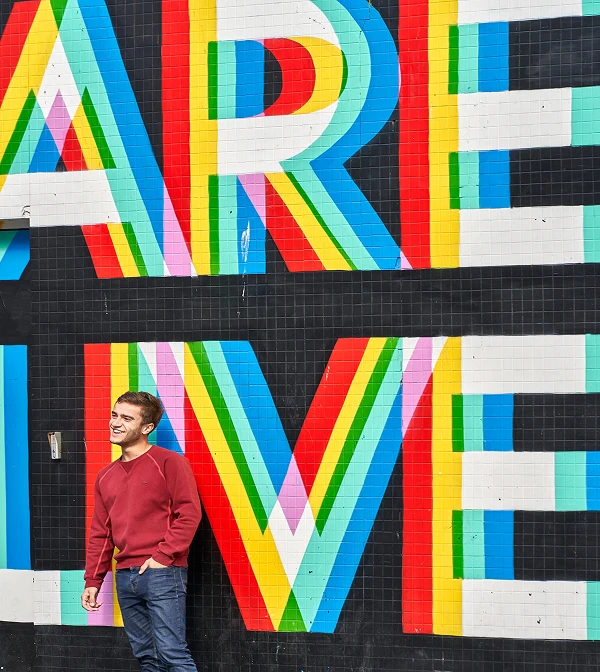 Man standing in front of a graffiti wall