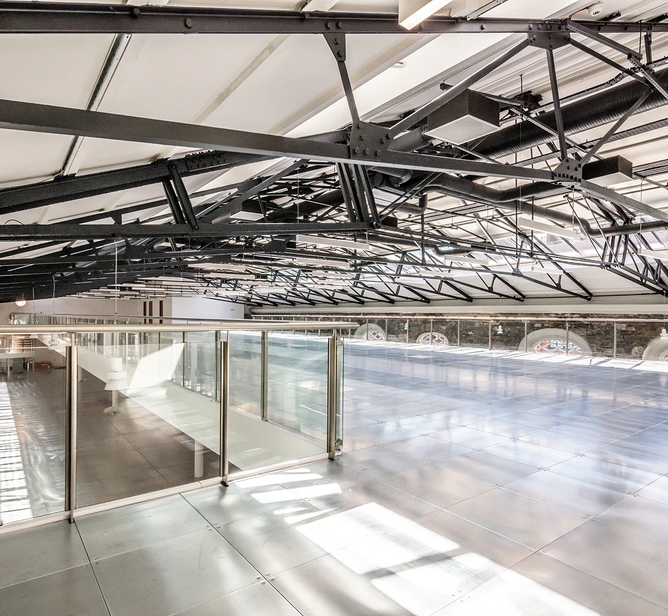 Upstairs workspace floor with exposed metal roof beams.