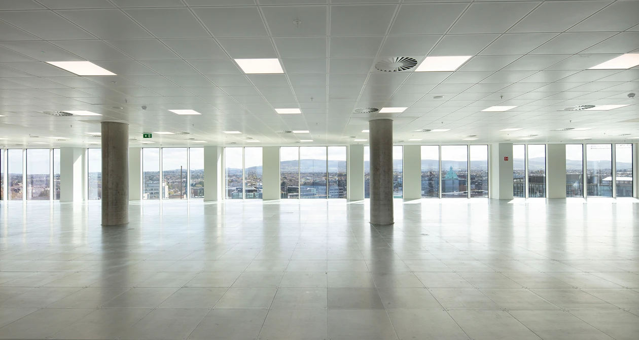 Empty workspace floor with windows showing Dublin city on the horizon.