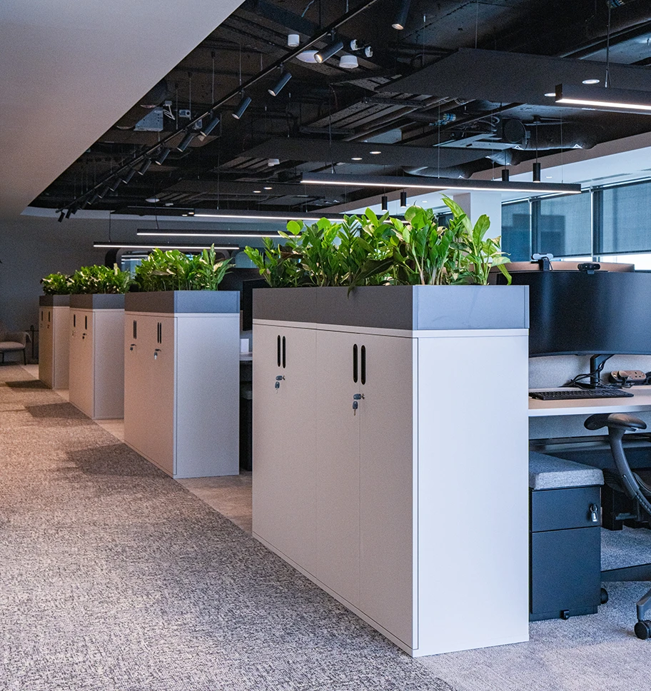 A filing cabinet at the start of each row of workstations .