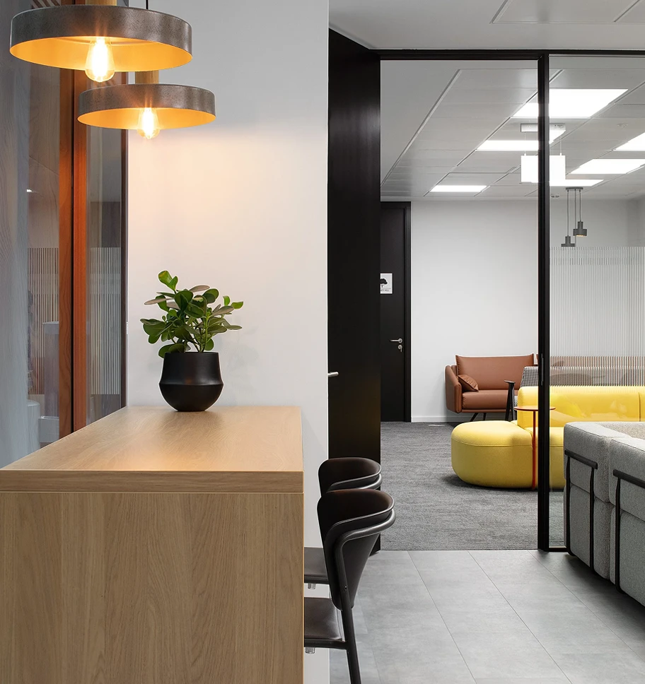 Breakout are with a wooden desk, chairs and yellow couch.