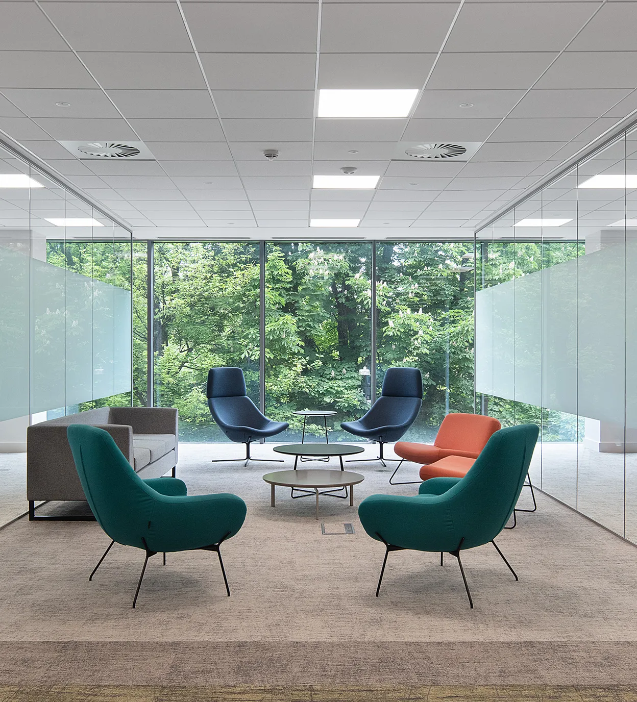 Glass walled workspace with a window showing trees from outside.