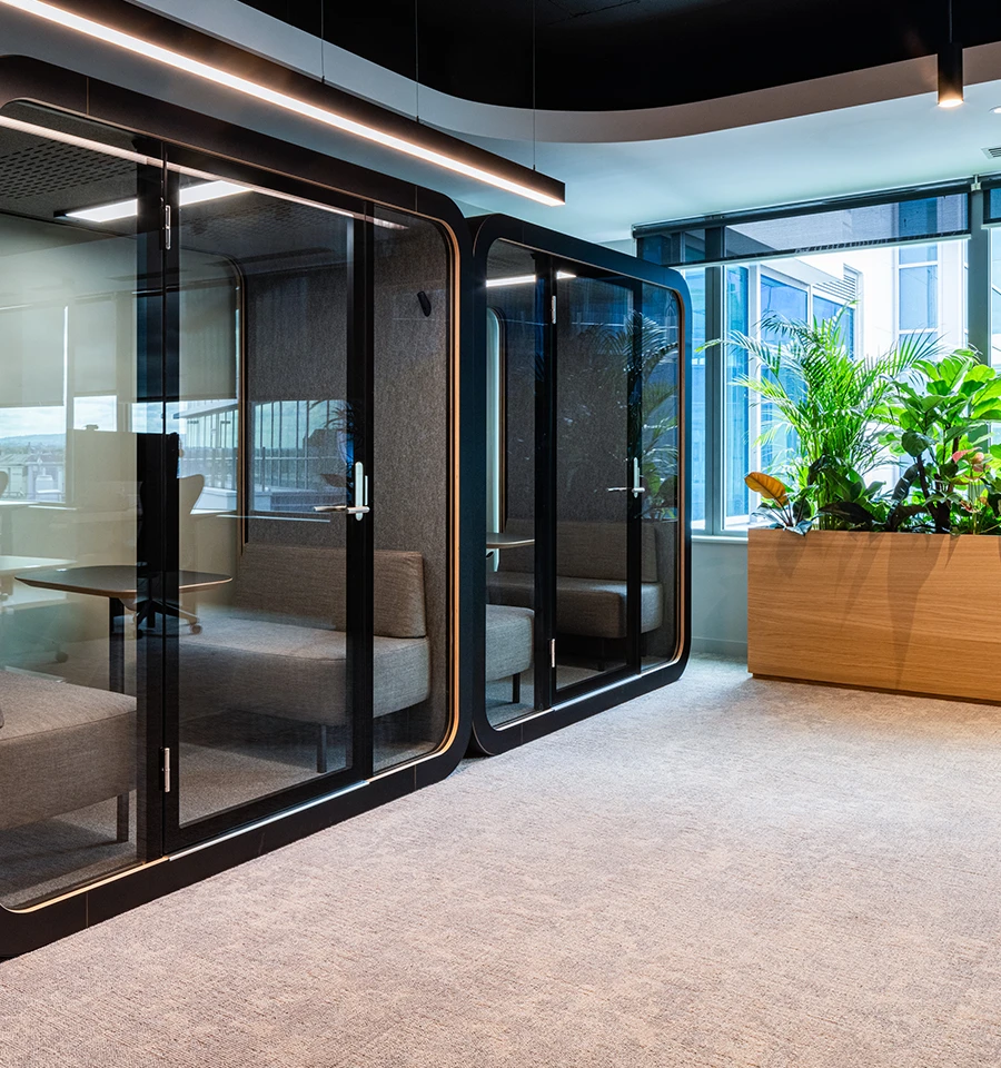 Workspace pods with plants outside the window.
