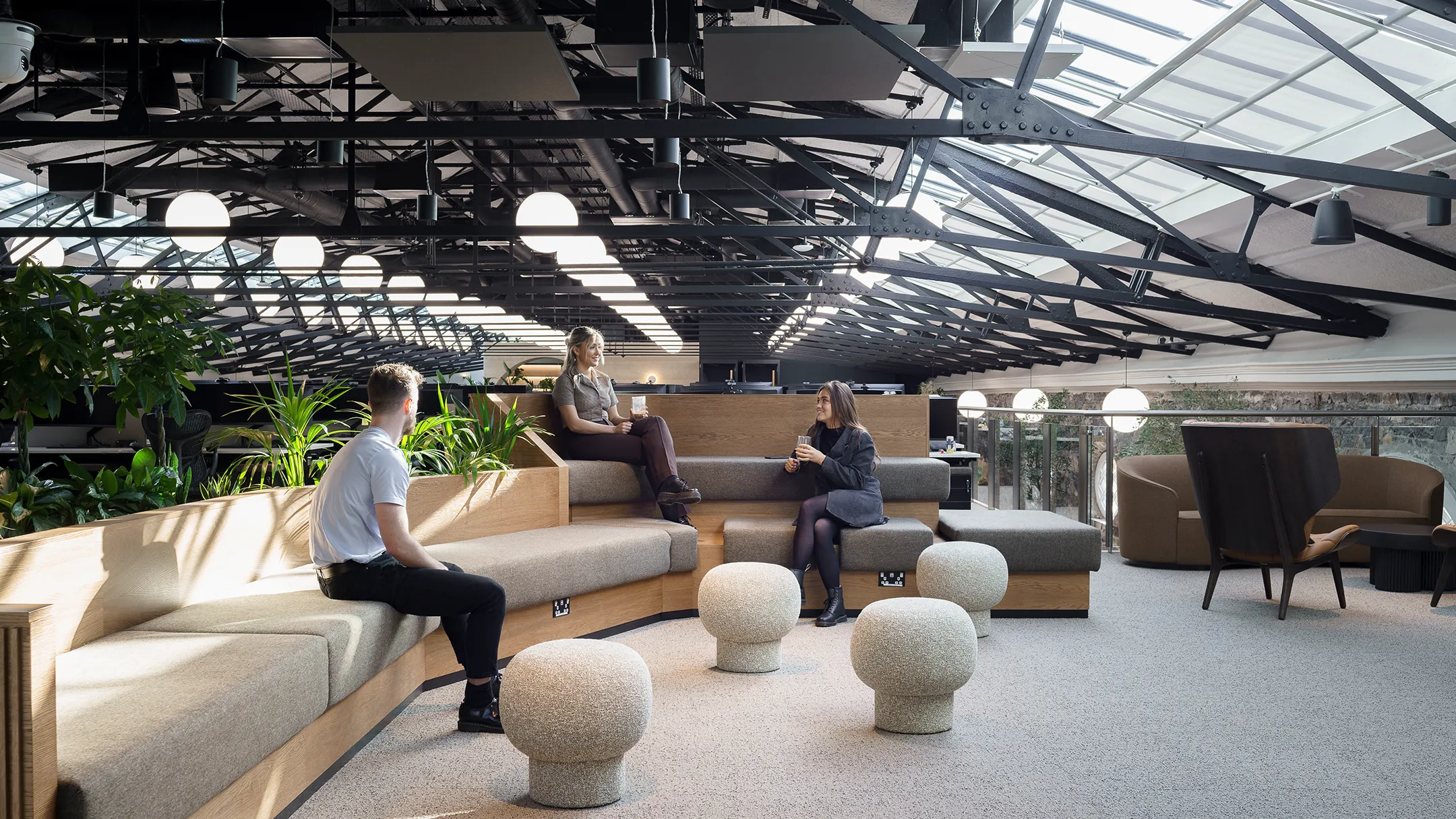 Breakout area with soft levelled seating and exposed roof beams.