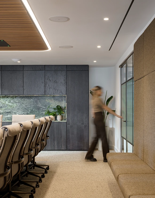 Staff member exiting a meeting room glass door.