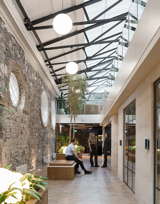 Staff talking in bright natural light hallway.